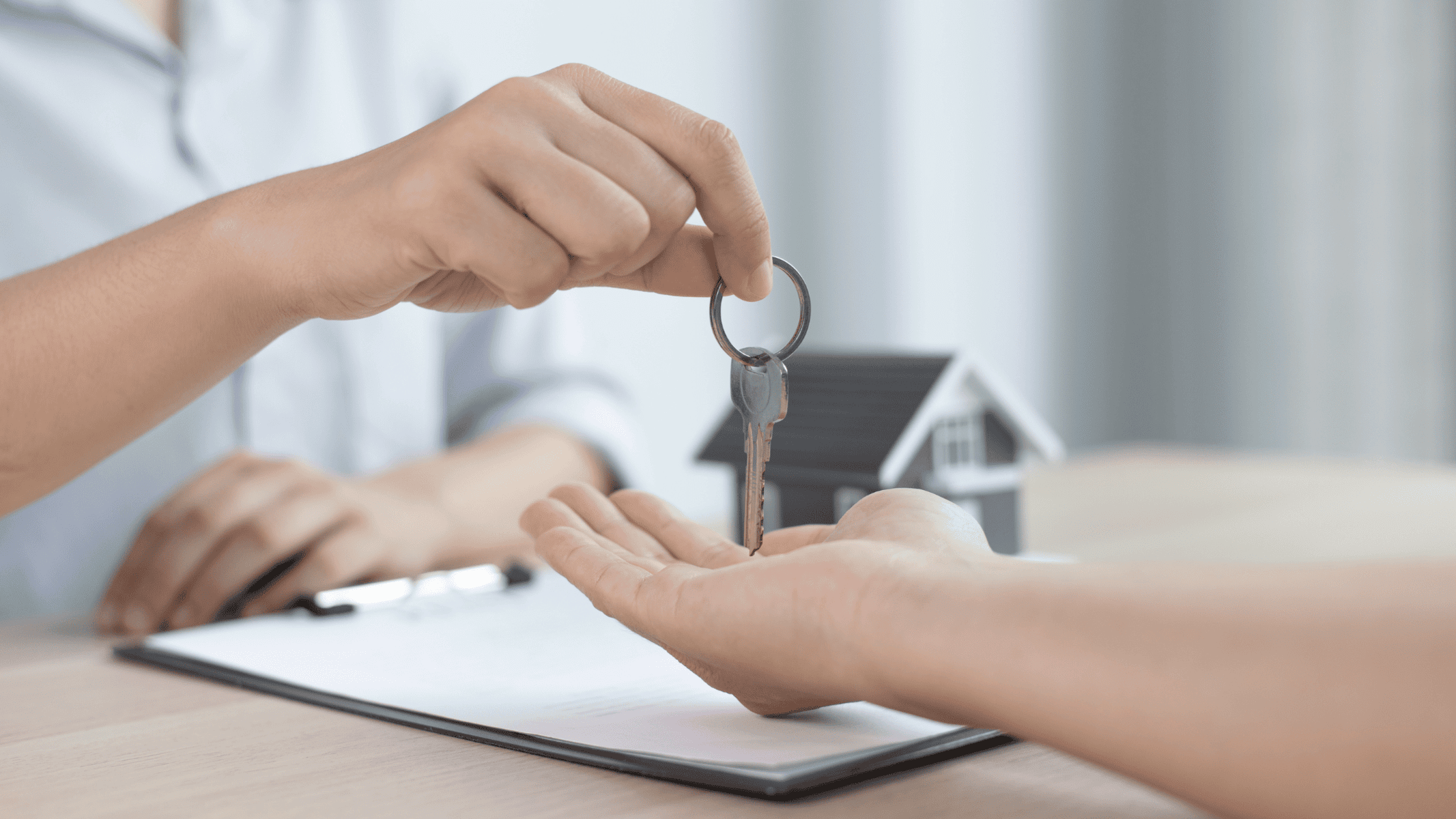 A person handing a key to another person